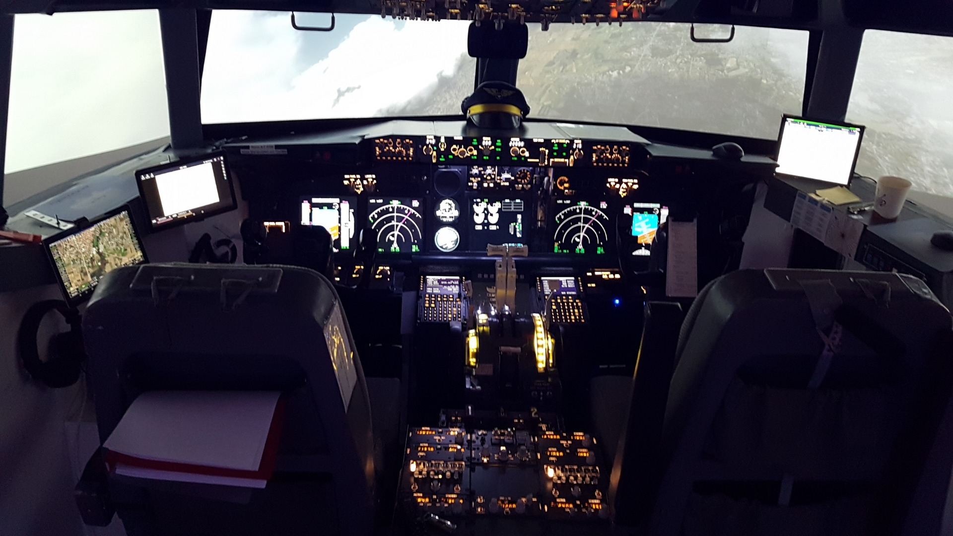 Blick in das Boeing 737-800 NG Cockpit von Flugsimulation-VFR mit beleuchtetem Instrumentenpanel, Overhead-Panel und Mittelkonsole.